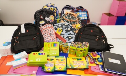 A neatly stacked collection of school supplies to be donated